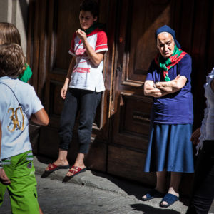 Una suora assiste alla processione con i colori del proprio quartiere al collo (Arezzo 2009)
